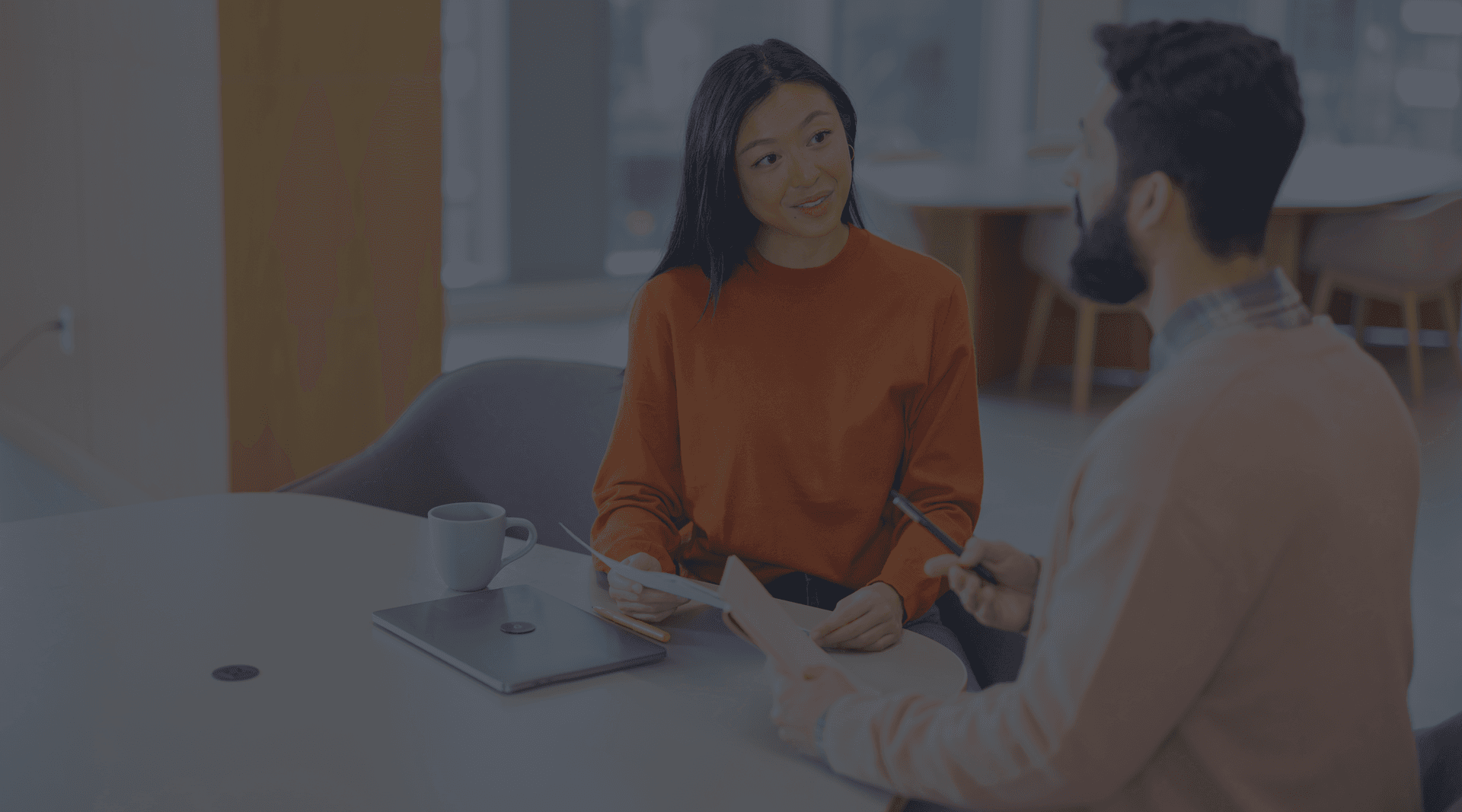 Image of two people working at a table.