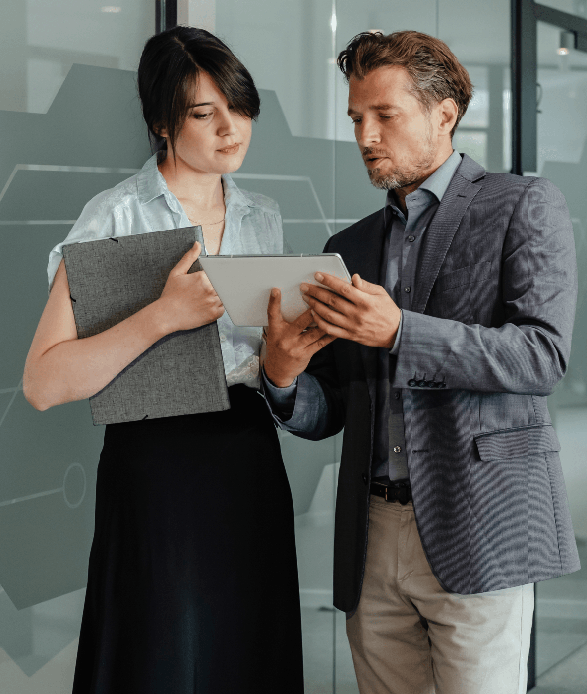 A man and a woman are looking at a tablet together.