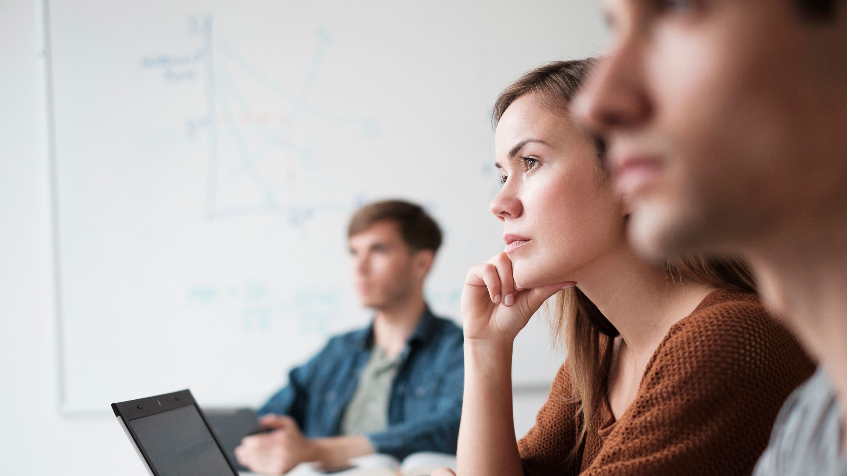 Students attentively listening in a classroom.