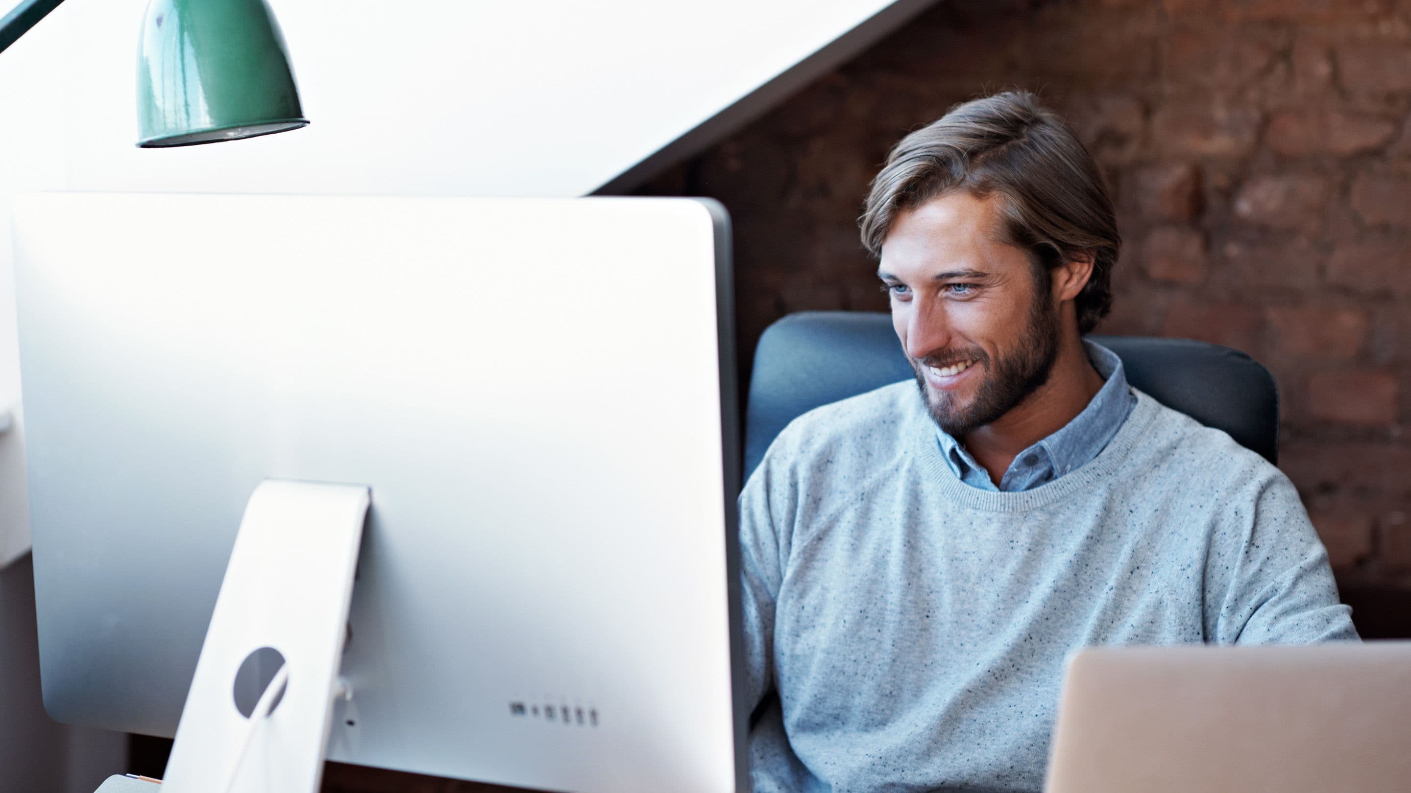 Smiling man working on a computer.