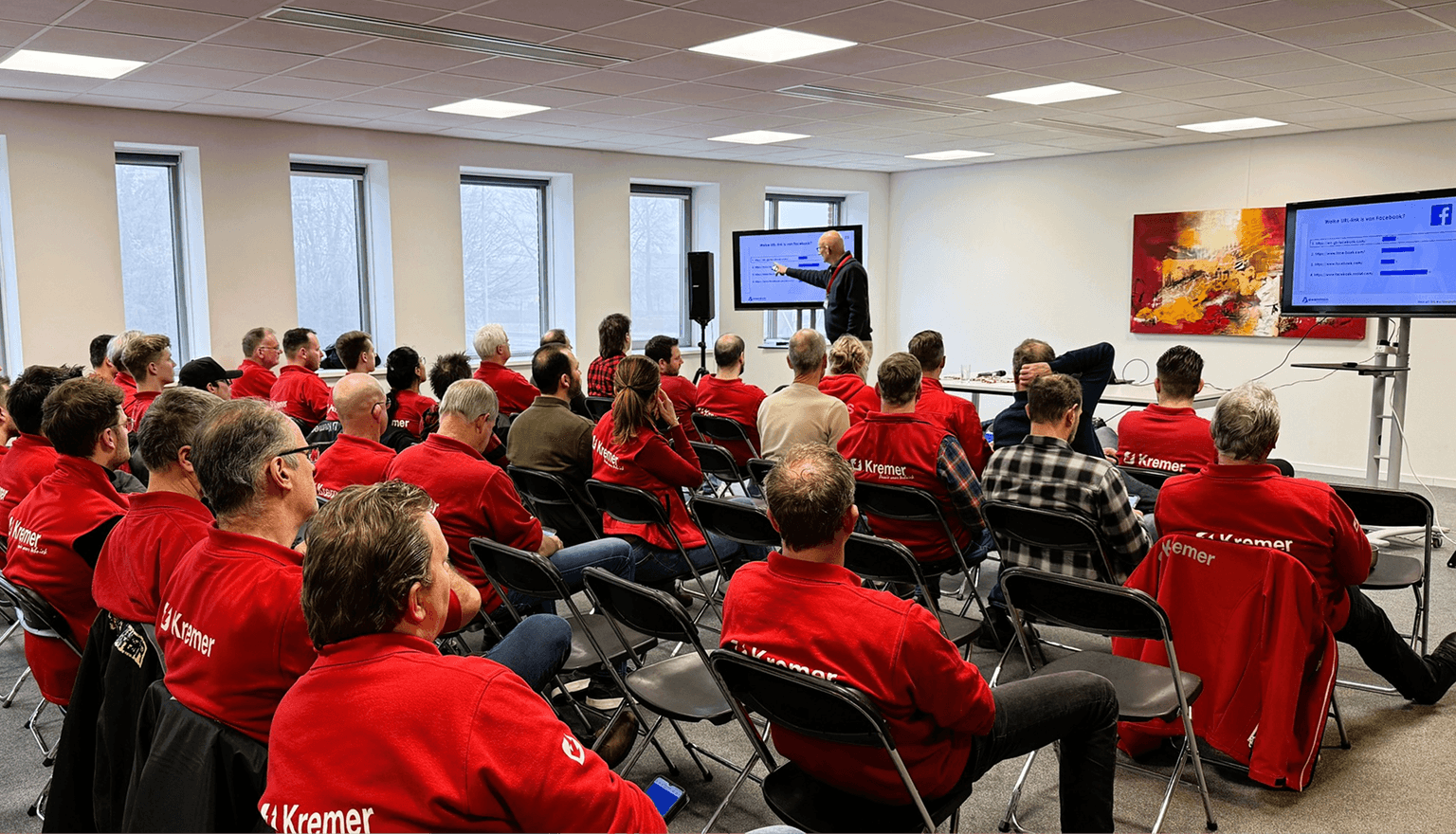 Team members watching a presentation on two screens.