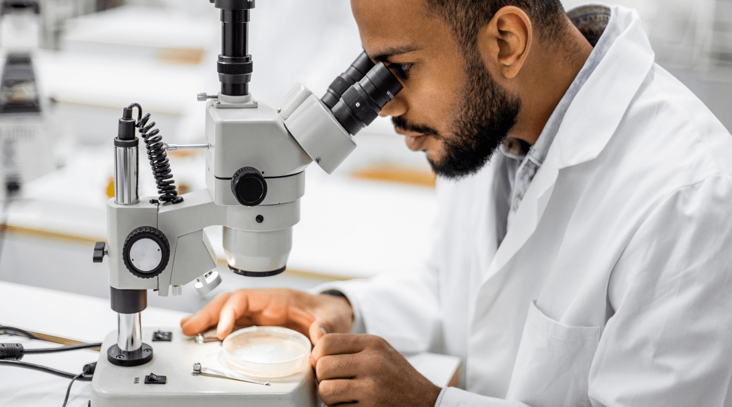 Scientist looking though a microscope.