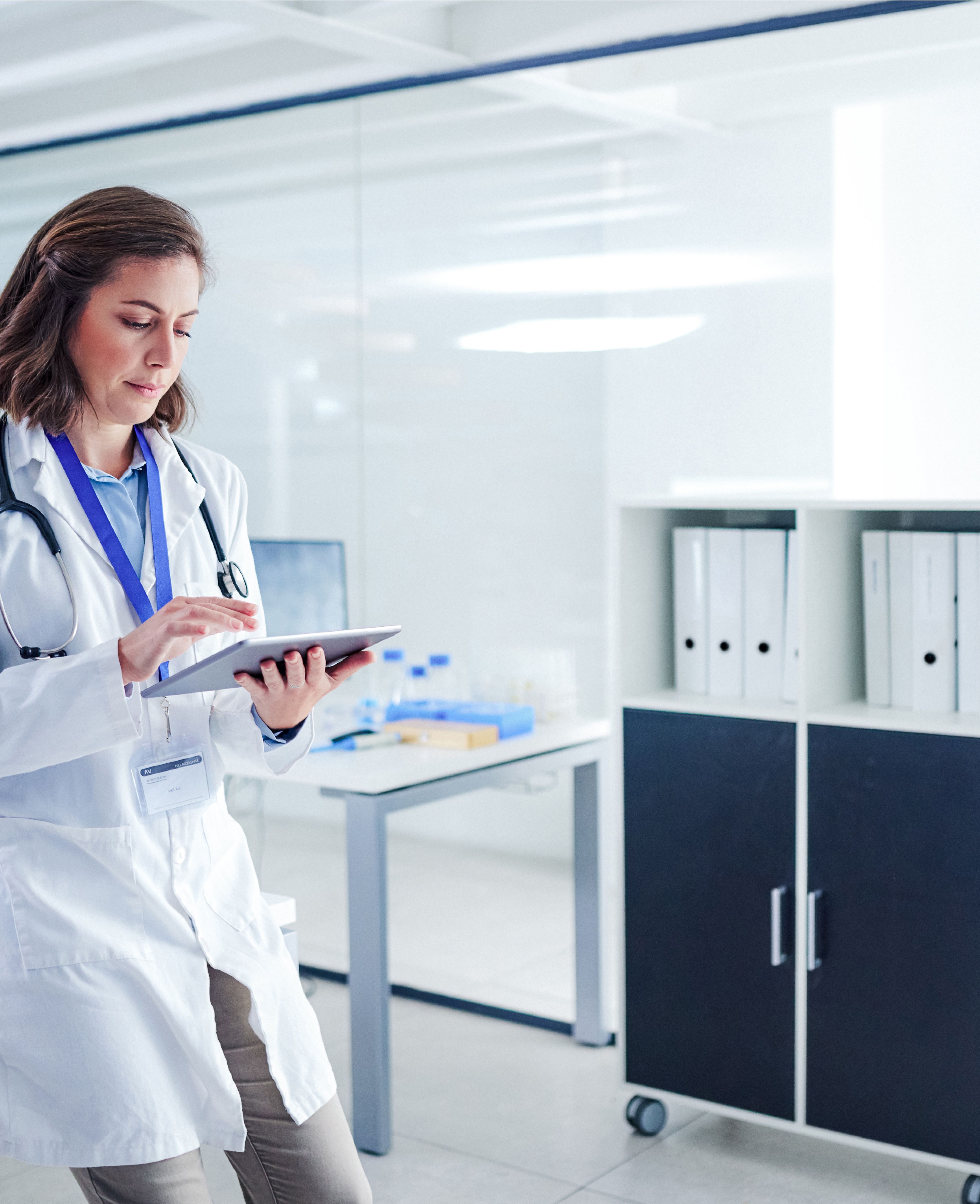 A female doctor is using a tablet computer in an office.