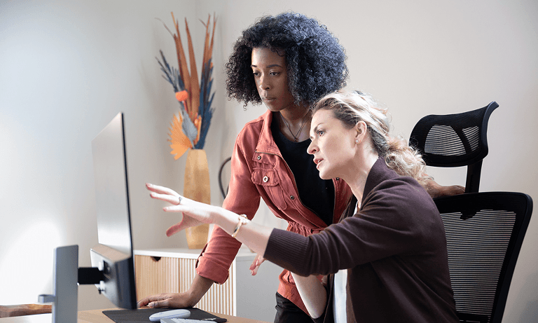 Image of two women working at a computer.
